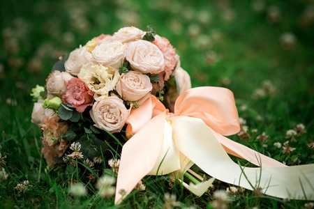 Picture of a wedding bouquet , Wedding bouquet of pink and white roses lying on grassの写真素材