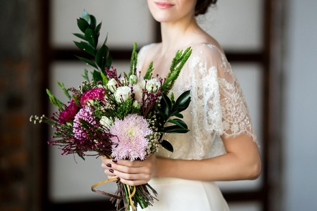 Beautiful Bride holding big wedding bouquet on wedding ceremonyの写真素材