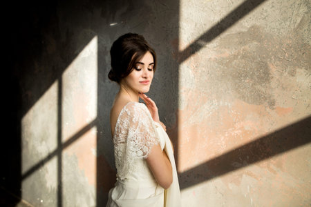 Portrait of beauty bride in white dress. Bride in a luxury apartment in a wedding dress.の写真素材