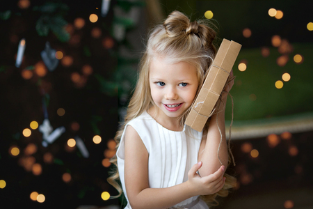 Happy little smiling girl with christmas gift box. Merry Christmas and Happy Holidays.の写真素材