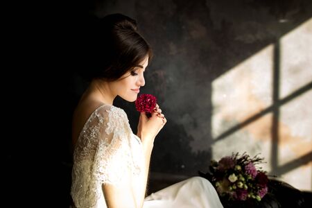 Wedding fashion bride with bouquet in hands. Portrait of beauty bride in white dress.の写真素材
