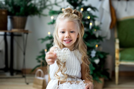 Happy little smiling girl with christmas gift box. Merry Christmas and Happy Holidays.の写真素材