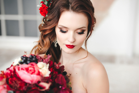 Beautiful bride with an original wedding bouquet in a vintage interior.の写真素材