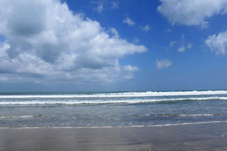 White clouds, blue sky and wavy oceanの写真素材