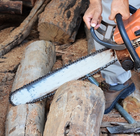 Man cutting piece of wood with chain saw.の写真素材