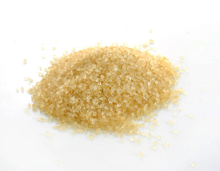 Crystals cane sugar heap close up isolated on whiteの写真素材