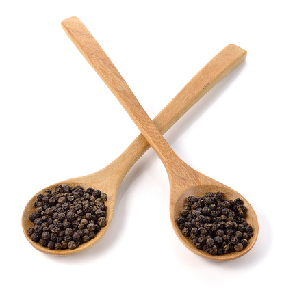 Wooden spoon and peppercorn on white backgroundの写真素材