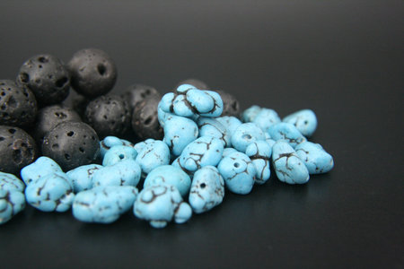 turquoise blue and black gemstones beads on black backgroundの写真素材
