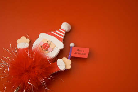 Red santa claus toy with Merry christmas sign on red backgroundの写真素材