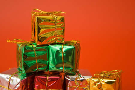 gold silver and green christmas gifts decoration on red backgroundの写真素材