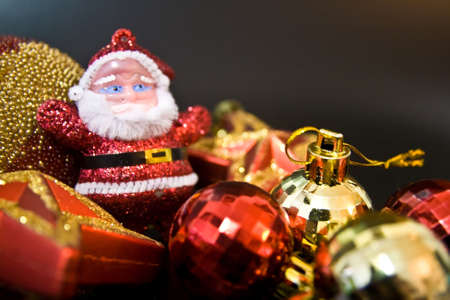 Santa claus toy with christmas ornaments on black backgroundの写真素材