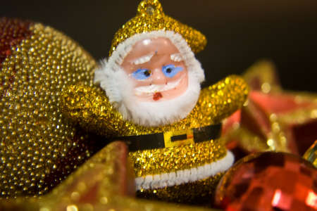 Red santa claus toy with christmas ornaments on black backgroundの写真素材