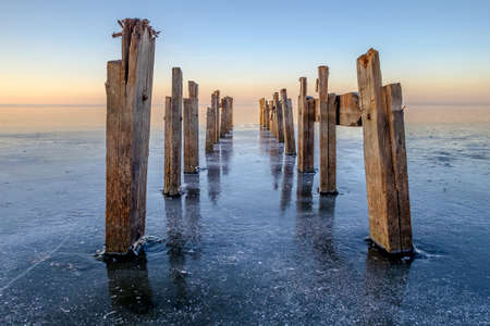 Boat dock on a frozen lake. Sunset, reflectionの写真素材