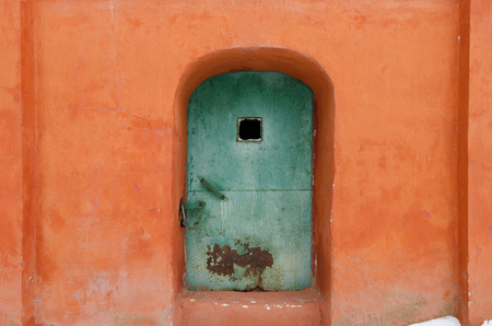 Old door in the stone wall. The walls are covered with plaster orange. The church in the city of Yaroslavl. Russia.の写真素材