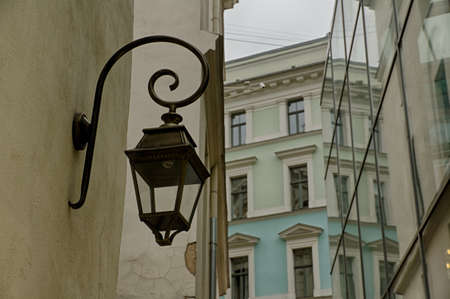Street lamp and part of the glass facade of the building. In the background, the old house is visible. Riga. Latvia.の写真素材