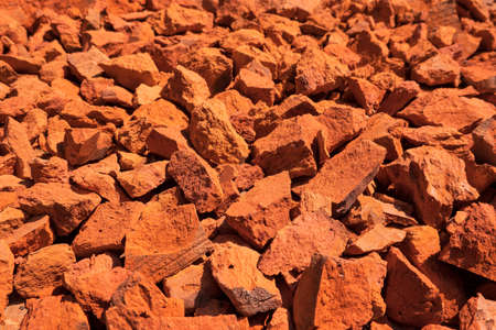 A look at the perspective of a surface covered with pieces of broken red brick. Background. Texture.の写真素材
