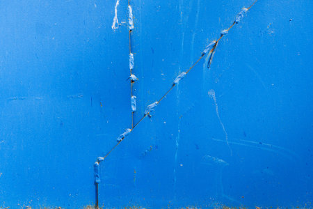 The blue metal surface is assembled from three parts of various shapes. There are traces of welding and small foci of corrosion. Background. Texture.の写真素材