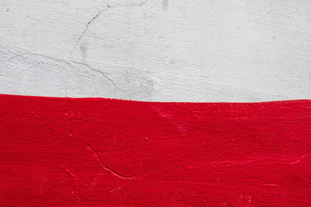 Fragment of a wall painted with white and red paint. There is a concrete surface texture and an uneven border between different colors. Background Textureの写真素材