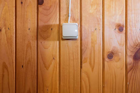 White electrical switch on a yellow wooden wall. background. texture.の写真素材