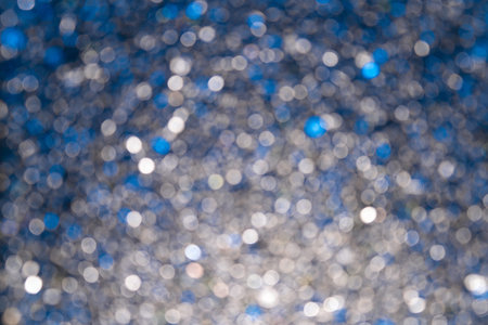 Blue and white glitter bokeh on a silvery background. background. defocused.