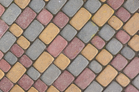 A fragment of a pavement made of paving slabs of different sizes and colors. Background. Texture.
