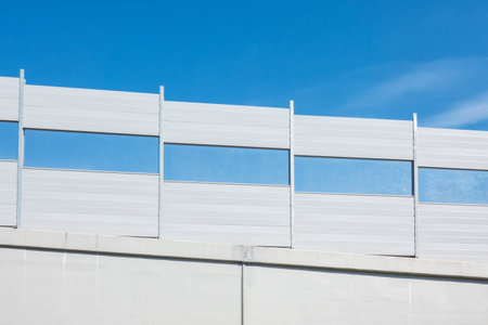 Soundproof shields for the road fencing at the descent from the overpass. There is a blue sky. Background.の写真素材