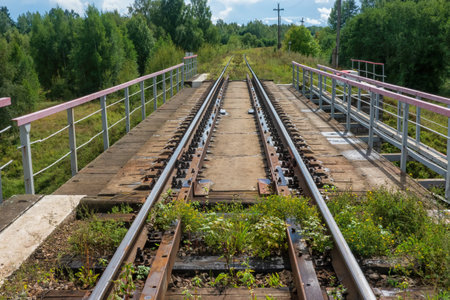 View along the rails to a small concrete railway bridge, There are trees around the road. Background. Landscape.の写真素材