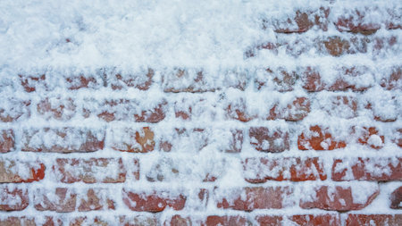 Old red brick wall with snow stuck to it. Background. Textureの写真素材