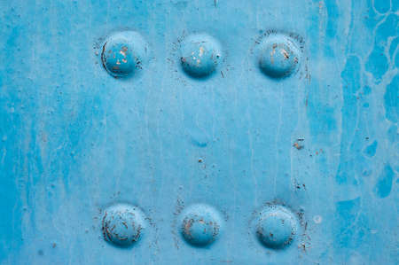 old blue rusty sheet metal with rivetsの写真素材