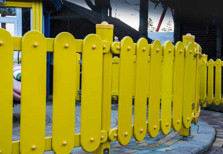 plastic low decorative fence outdoors on sunny day at the city parkの写真素材