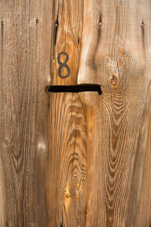 Number eight on a wooden door in a barn, closeup of photoの写真素材
