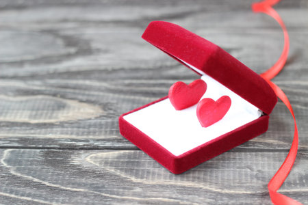 Red box for jewelry in which are two small red hearts. Valentine's Day .