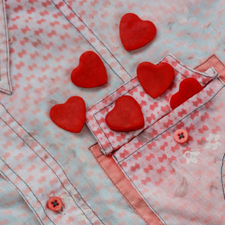two hearts on the background of a pink shirt pocket. close-up.Valentines Day background consept.の写真素材