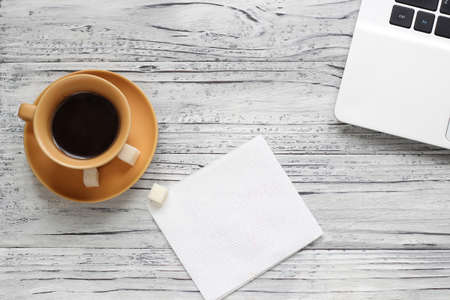 Background of a valentine on a wooden table with a laptop cup of coffee hearts beside a napkin for writing. Valentine's Day.の写真素材