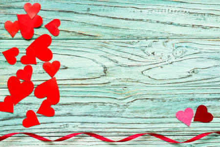 Paper hearts are red in the background of a turquoise tree. The concept of Valentine's Day.の写真素材