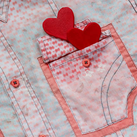 two hearts on the background of a pink shirt pocket. close-up.Valentines Day background consept.の写真素材