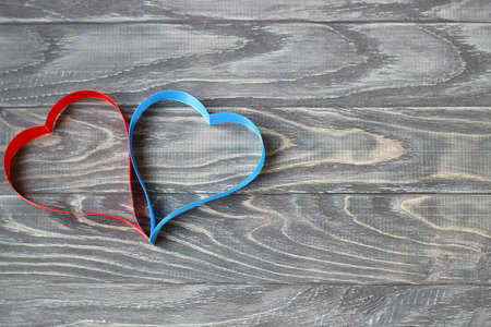 Valentine's Day . Two hearts of ribbons of red and blue on a background of wood.の写真素材