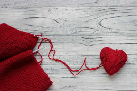 Heart in the form of a string of threads from which a red sweater knits. Valentines day concept.の写真素材