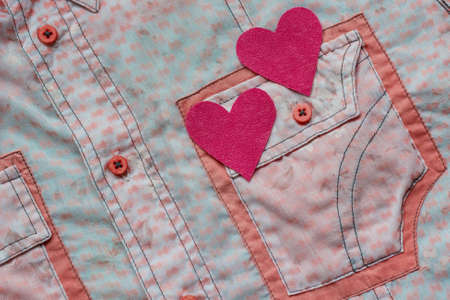 two hearts on the background of a pink shirt pocket. close-up.Valentines Day background consept.の写真素材