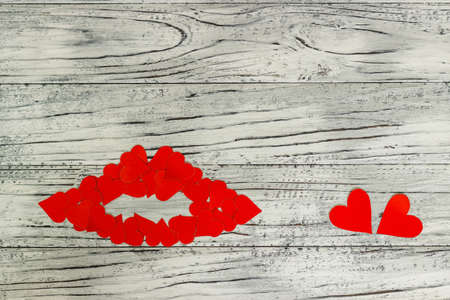 Lips of little red hearts on a wooden background. The concept of Valentine's Day.の写真素材