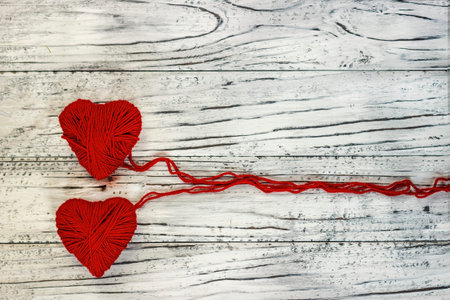 Heart in the form of a string of threads from which a red sweater knits. Valentines day concept.