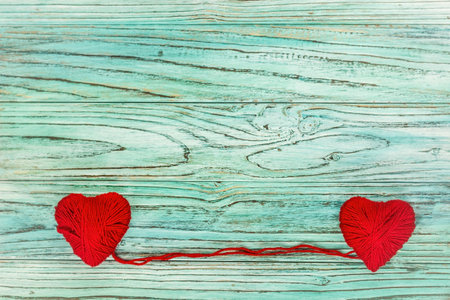 Heart in the form of a string of threads from which a red sweater knits. Valentines day concept.