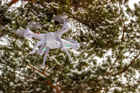 Flight of the drone in the winter forest. The concept of unmanned aerial vehicles. UAV, technology...