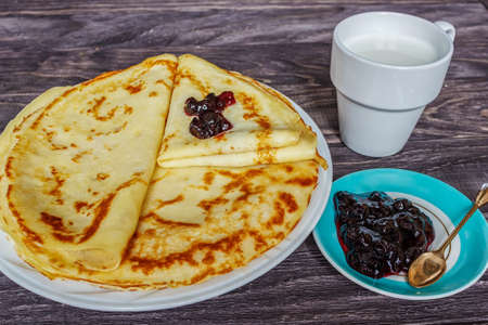 Pancakes on a white plate with honey and a cup of milk. Tasty breakfast.

Homemade pancakes with jam, close-upの写真素材