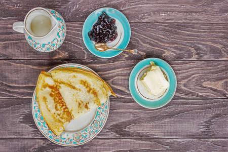 Freshly prepared pancakes for breakfast near jam, a glass of milk and butter, top view, horizontal.の写真素材