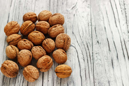 Whole walnuts on a white wooden background.の写真素材
