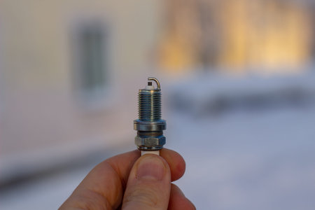 New spark plug in hand. Replacing spark plugs in the car.