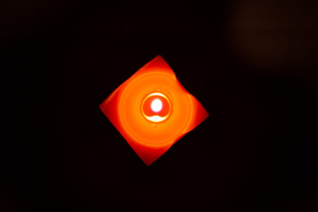 Closeup of burning candle isolated on black background.の写真素材