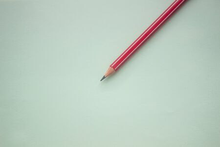 One red pencil on a light green backgroundの写真素材