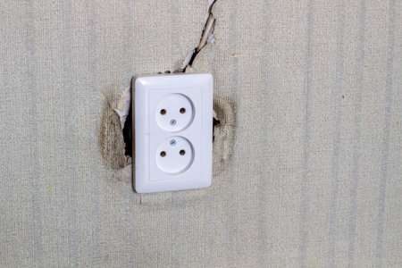 Undone AC power socket in wall. Repairs in the apartment.